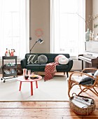 Roter Couchtisch, verschiedene Sitzmöbel, mobile Minibar und Klavier vor raumhohem Fenster im Wohnzimmer