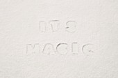 Lettering reading 'IT'S MAGIC' pressed into flour