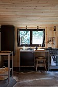 Minimalist kitchen counter below window in wood-clad kitchen with animal-skin rug