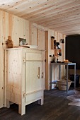 Rustikaler Holzschrank in moderner, holzverkleideter Küche mit ländlichem Flair