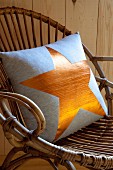 Cushion with gold star motif on wicker chair
