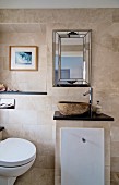 Gemauerter Waschtisch mit Steinschüssel und Toilette in elegantem Bad mit Sandsteinfliesen