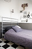 Bed with modern headboard made from metal bars; pictures and fabric hunting trophy on wall