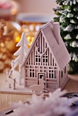 White wooden house and deer Christmas ornaments (close-up)