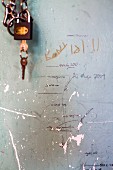 Padlock next to hand-drawn height scale on battered wall