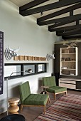 Living room with retro easy chairs and stylised hunting trophies on wall above ribbon window