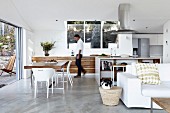 Designerküche mit Essplatz in offenem Wohnraum, im Vordergrund weiße Couch