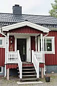Traditional Swedish house with steps leading to porch and open front door