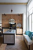 Vintage bird cage hung from load hook above island counter in modern, loft-apartment kitchen with window seat