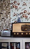 Retro radio on cabinet against wall with two patterns of wallpaper