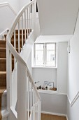 Stairwell with white-painted wooden staircase in period apartment