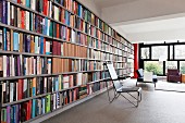 Stuhl auf Metallgestell vor Bücherwand in offenem Wohnraum mit Bauhausflair