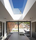Point 7, Winchester, United Kingdom. Architect: Dan Brill Architects, 2014. View from kitchen to sunny terrace on multiple levels through sliding terrace doors