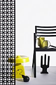 Chair and partition with graphic floral patter arrangement with bizarre objets d'art in black and yellow