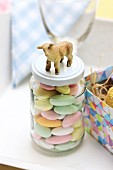 Sugared almonds for Easter in screw-top jar decorated with lamb figurine