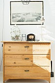 Retro birdcage, cake stand and frame black and white photo on pale, wooden chest of drawers