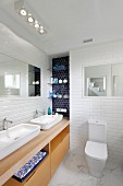 Waschtischzeile mit zwei Aufbaubecken auf Holz Unterschrank in weiss gefliestem Bad, Boden mit Marmorbelag