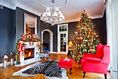 Red armchair and footstool and zebra-skin rug in front of decorated Christmas tree