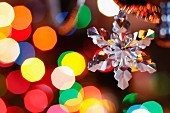 Retro, glass snowflake Christmas decoration with colourful spots of light