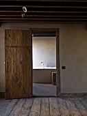 Offene Zimmertür in rustikalem Stil und Blick auf Badewanne
