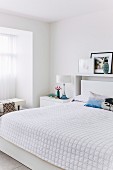 weiße Tagesdecke auf Doppelbett in modernem Schlafzimmer