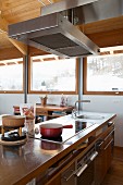 Hob on free-standing counter below extractor hood in modern chalet