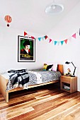 Bunting and film poster (Amélie) above solid-wood teenager's bed on parquet floor made of spotted gum wood native to Australia