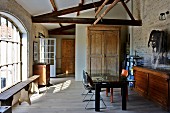 Partially renovated barn - simple furnishings in mixture of styles, modern table, wooden trunk, rustic wooden bench and lattice window