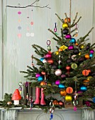 Christbaum mit bunten Kugeln, Gummistiefel und Weihnachtsdeko auf dem Kaminsims