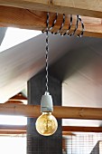 Pendant lamp with simple light bulb and cord wrapped around wooden beam