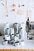 Hand-crafted ceramic vases next to sewing machine on workbench