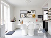 White Panton chairs around an oval table in an open plan dining room with terrorist doors and country house-style charm