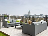 Elegant grey sofas and low coffee table on roof terrace with wooden decking