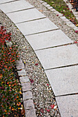 Gartenweg mit Steinplatten auf Kiesuntergrund