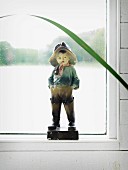Vintage angler figurine in front of misted window