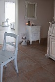 White chair and shabby-chic cabinet on large floor tiles in hallway