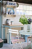 Blue and white country-house kitchen with wooden table and wall-mounted shelves