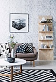 Shelf leaning against the wall, sofa with pillows, carpet with black and white pattern