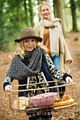 Mother and daughter having autumn picnic in woods