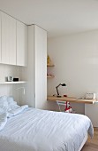 White, teenager's bedroom with custom fitted furnishings, bed and desk