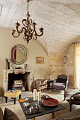 Vintage chandelier hanging from stone vault in rustic interior with open fireplace