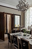 Silver candelabra on dining table and antique chairs in elegant dining room