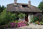 Kleines Steinhaus mit üppigen Hortensienbüschen