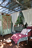Antique furniture, quilt on chair, framed pictures on top of cabinet and shabby-chic cupboard in vintage-style conservatory