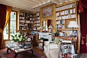 Bookcases, antique furniture and heavy curtains in vintage-style living room