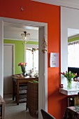 Open doorway in orange wall showing lime green walls in adjacent room