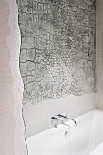 Spiegelreflektion einer Elefantenhaut-Struktur über der Wanne in einem künstlerisch gestalteten Badezimmer