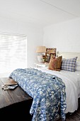 Rustic blue and white bedroom with old wooden trunk at foot of bed