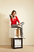 Woman sitting on stacked square shelving modules in black and white