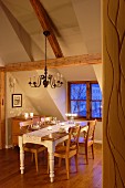 Dining area in attic with exposed wooden roof beams